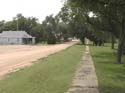 Rural sidewalk by gravel road.